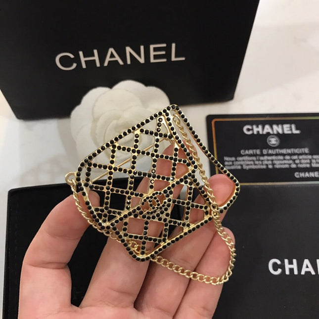 BAG SHAPED BROOCH IN GOLD METAL WITH BLACK CRYSTAL