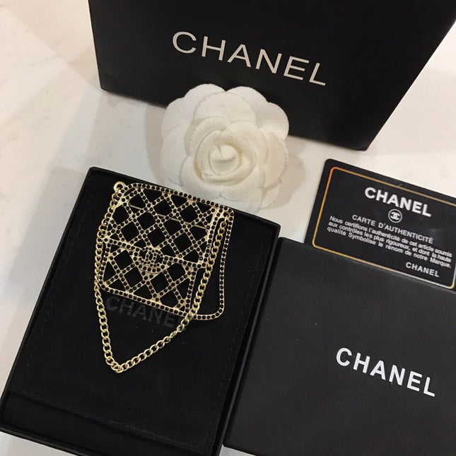 BAG SHAPED BROOCH IN GOLD METAL WITH BLACK CRYSTAL