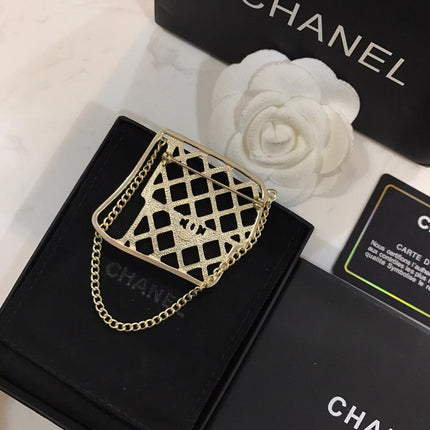 BAG SHAPED BROOCH IN GOLD METAL WITH BLACK CRYSTAL