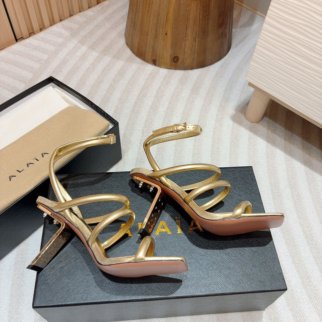ALAIA THREE-STRAPS HIGH HEEL SANDALS IN GOLDEN PATENT LAMBSKIN