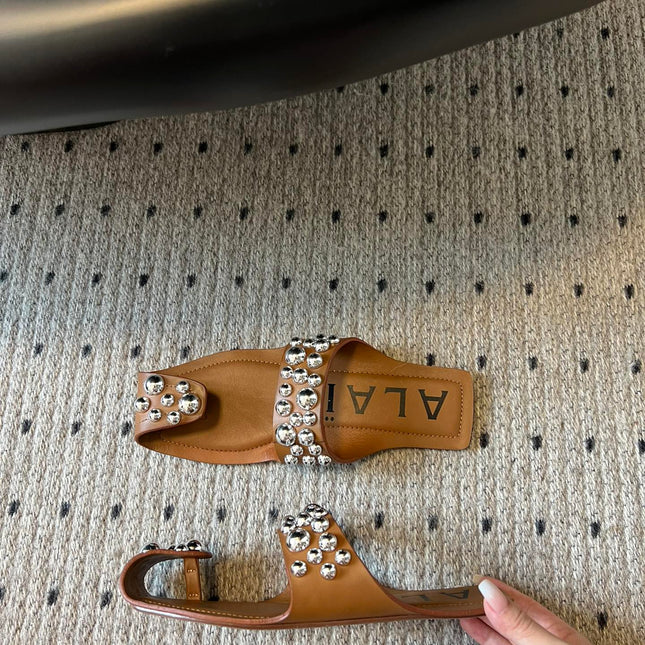 ALAIA FOLDED FLAT MULES WITH SPHERES ON COPPER BROWN CALFSKIN