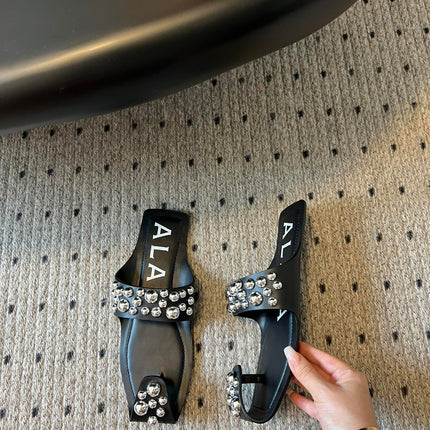 ALAIA FOLDED FLAT MULES WITH SPHERES ON BLACK CALFSKIN