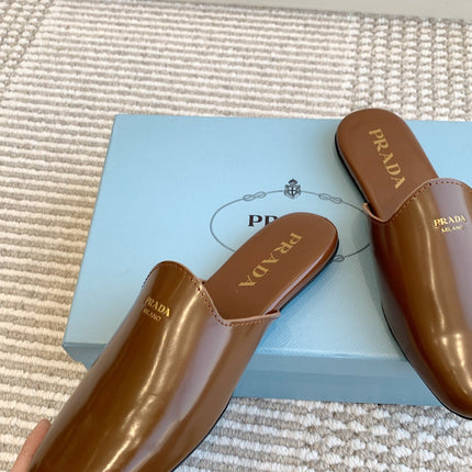 MULES IN BROWN GLOSSY SHEEPSKIN GOLD LETTERING LOGO