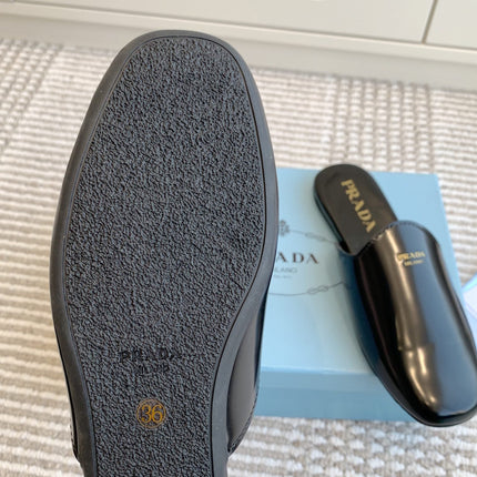 MULES IN BLACK GLOSSY SHEEPSKIN GOLD LETTERING LOGO