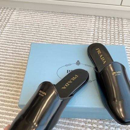 MULES IN BLACK GLOSSY SHEEPSKIN GOLD LETTERING LOGO