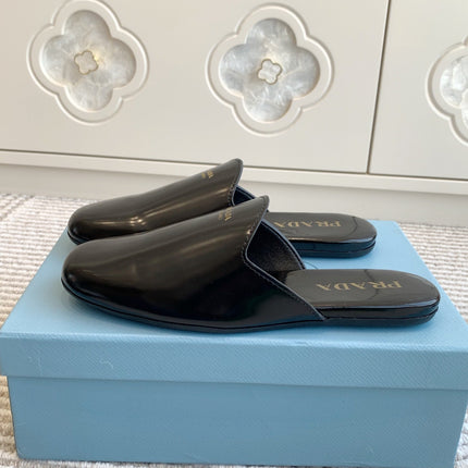 MULES IN BLACK GLOSSY SHEEPSKIN GOLD LETTERING LOGO