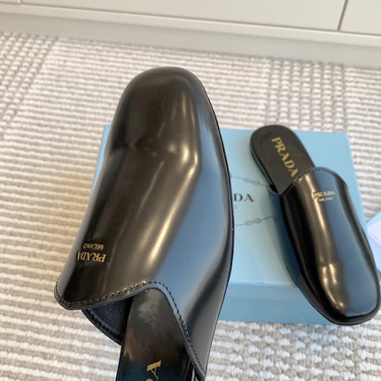 MULES IN BLACK GLOSSY SHEEPSKIN GOLD LETTERING LOGO