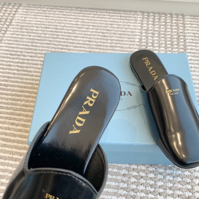 MULES IN BLACK GLOSSY SHEEPSKIN GOLD LETTERING LOGO