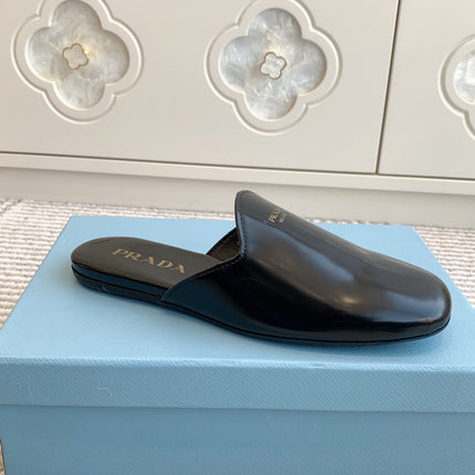 MULES IN BLACK GLOSSY SHEEPSKIN GOLD LETTERING LOGO