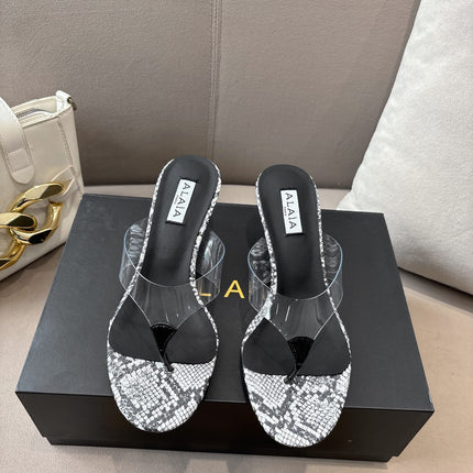ALAIA HEELED THONG 25S 55 MM IN WHITE AND BLACK LAMBSKIN SNAKE-EMBOSSED WITH CLEAR STRAP