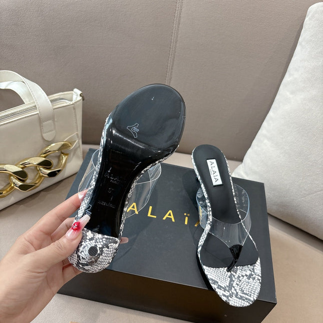 ALAIA HEELED THONG 25S 55 MM IN WHITE AND BLACK LAMBSKIN SNAKE-EMBOSSED WITH CLEAR STRAP