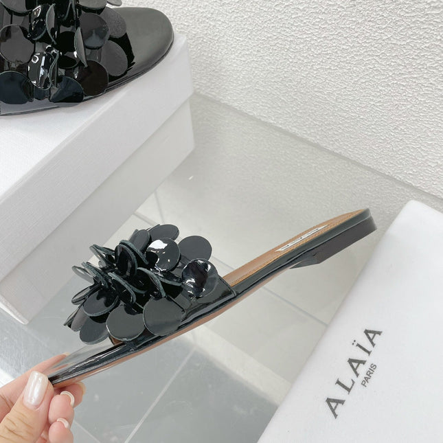 ALAIA FLAT MULE IN BLACK GLOSSY LAMBSKIN