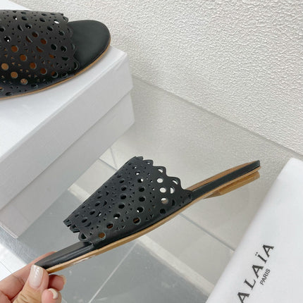 ALAIA VIENNE FLAT MULES IN BLACK LAMBSKIN