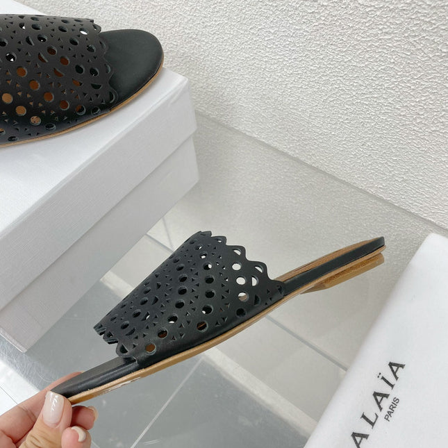 ALAIA VIENNE FLAT MULES IN BLACK LAMBSKIN