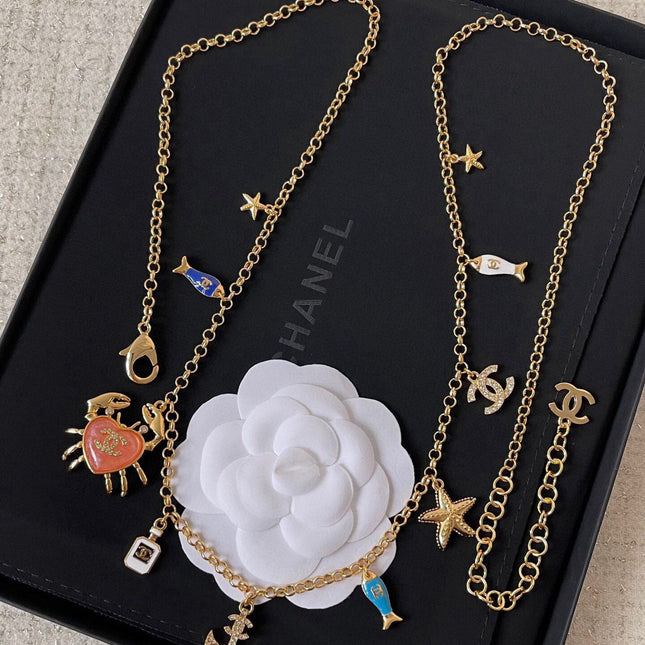 MULTI-CHARM CHAIN BELT IN GOLD METAL CRYSTAL DOUBLE C PENDANT AND OCEAN MOTIFS
